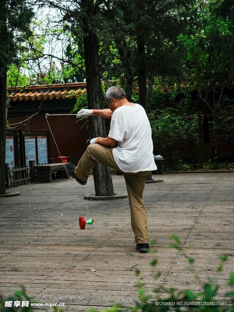 老人户外专注踢毽子