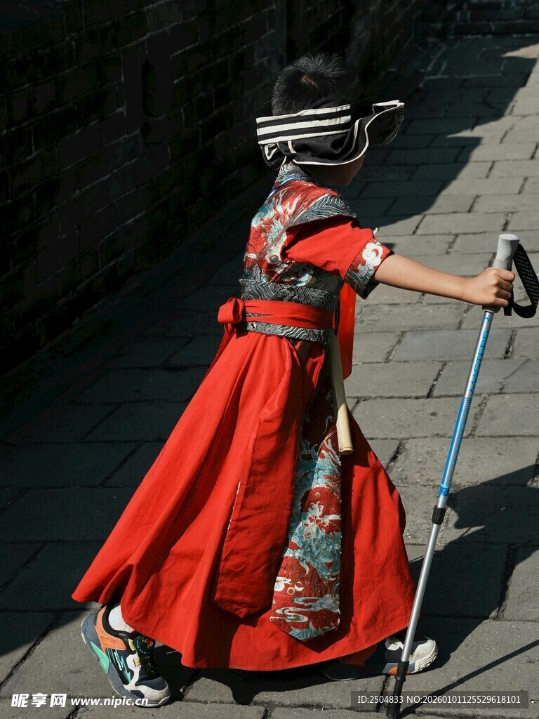 红衣女子头顶碗持杖走秀