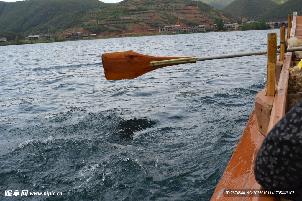 船桨入水于波光粼粼湖面