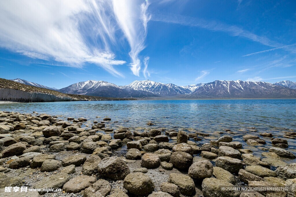 湖畔碎石与远处雪山美景