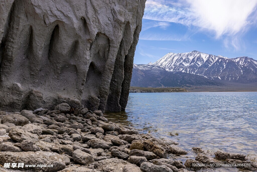 湖边嶙峋岩石与远处雪山