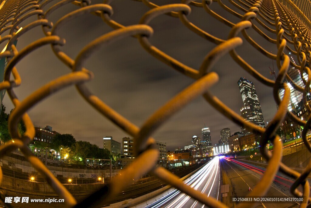 透过铁丝网的城市夜景
