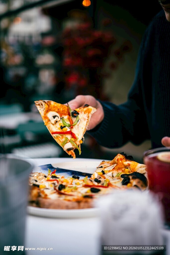 手持美味披萨的惬意时刻