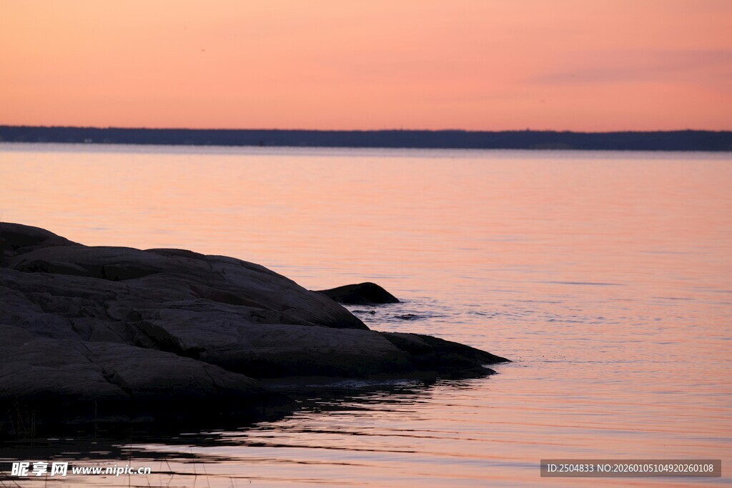 夕阳下的静谧海边岩石