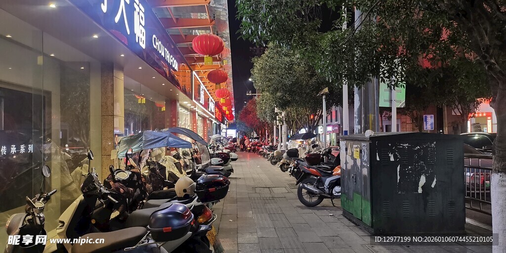 夜晚街边停放的多辆摩托车