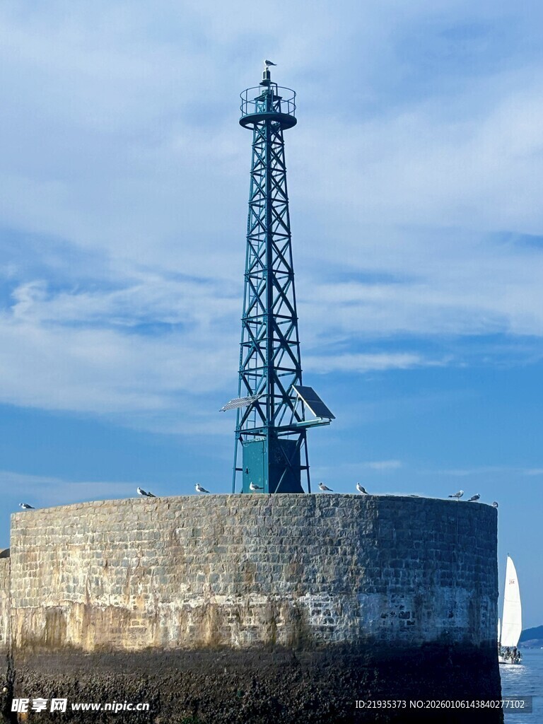 海边灯塔屹立于石砌平台