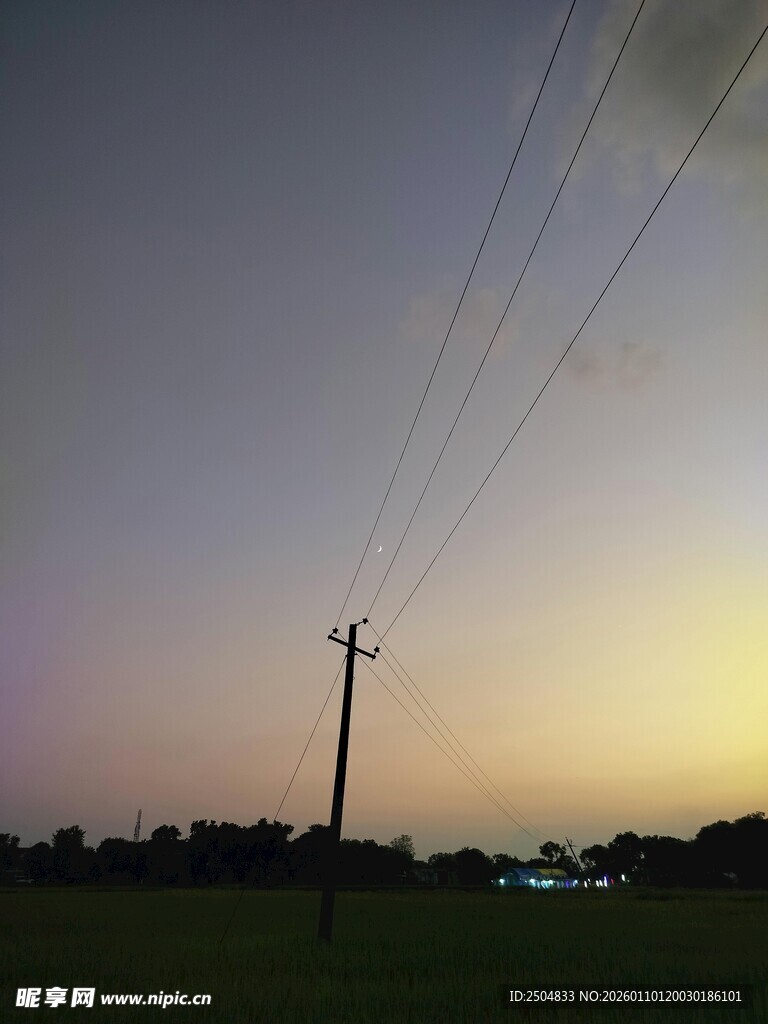 黄昏田野间的电线杆