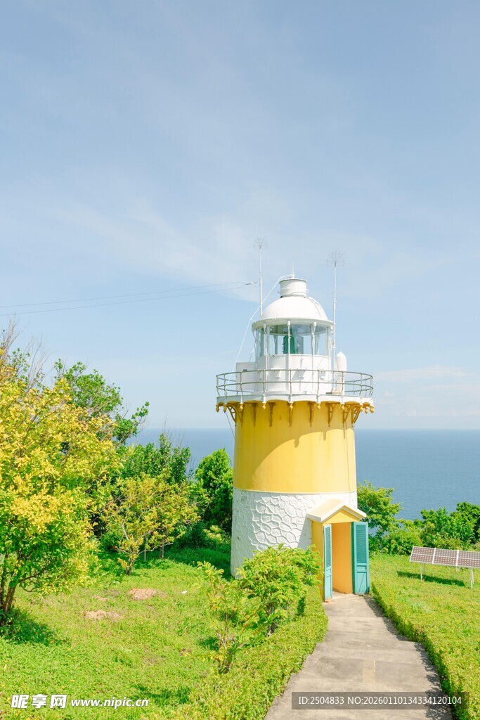 海边草地中的黄色灯塔