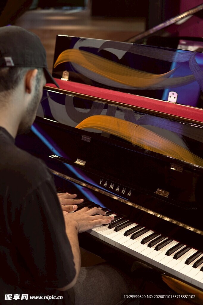 男子专注弹奏黑色钢琴
