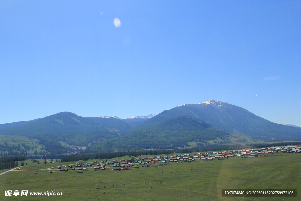 蓝天绿野间的巍峨山脉