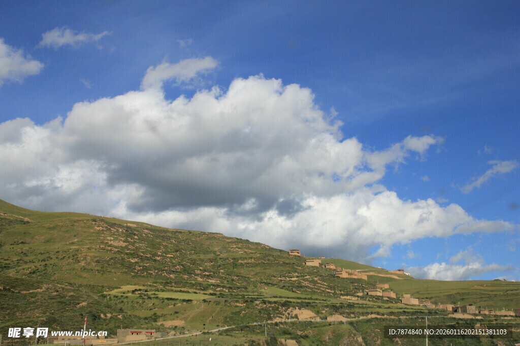 蓝天白云下的翠绿山坡