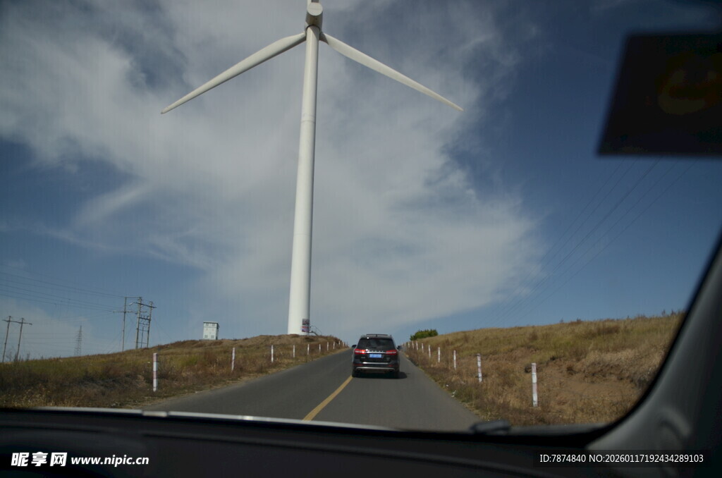 公路上驶向远方的风力发电机
