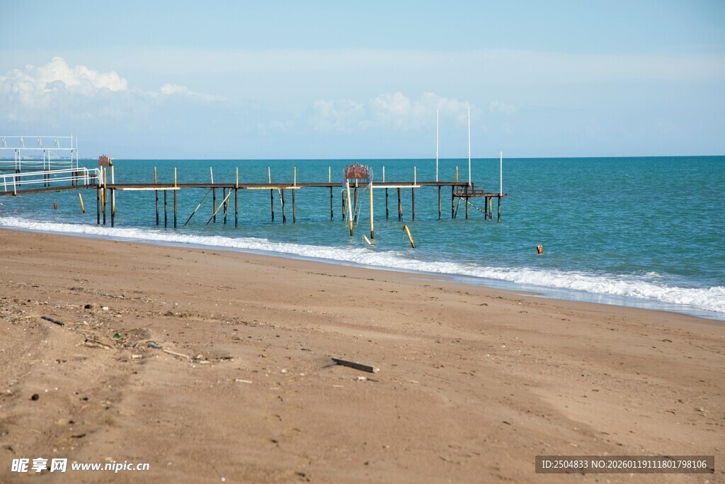 海滨沙滩与远处栈桥美景