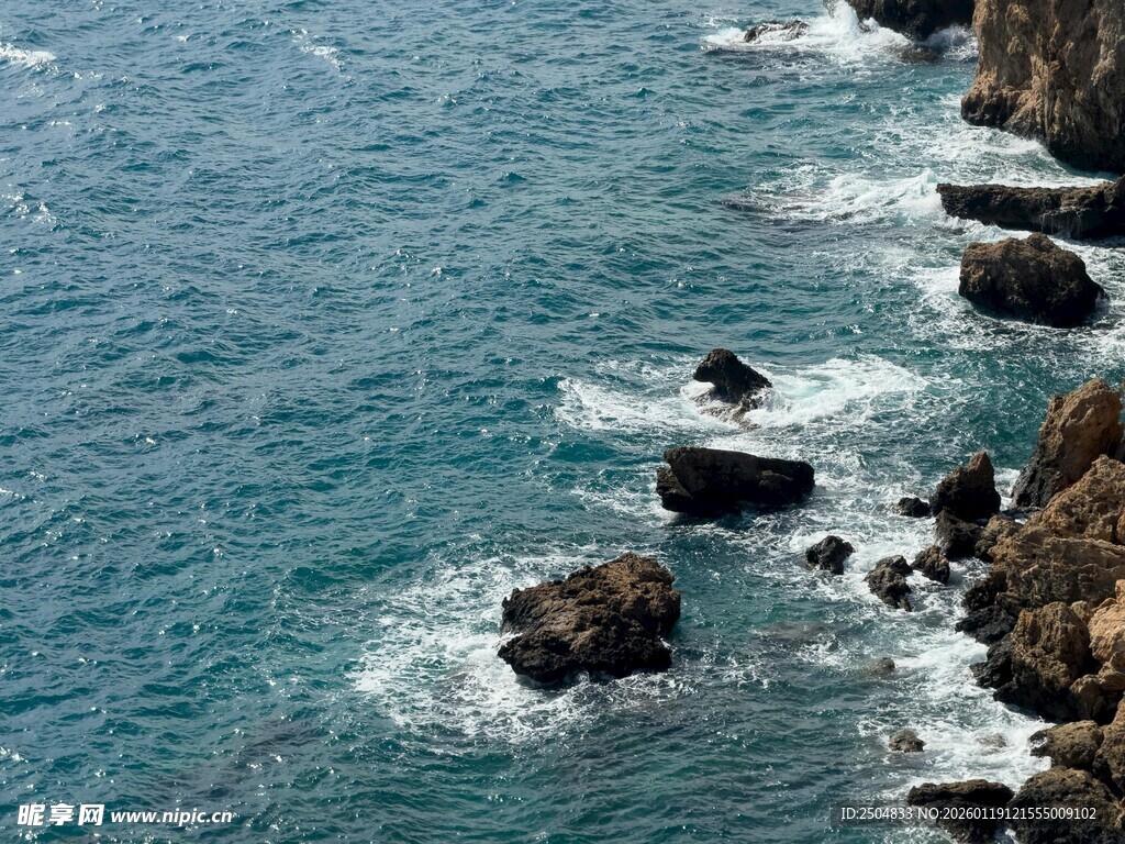 海边礁石与翻涌的蓝色海浪