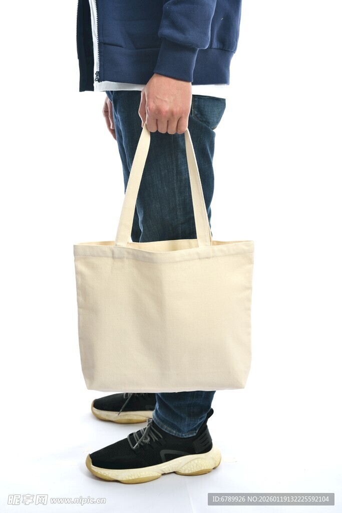 手持米色帆布手提袋的人