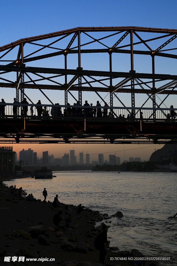 夕阳下桥上人群与河畔风景