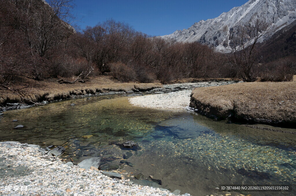 山间清澈溪流与远处雪山