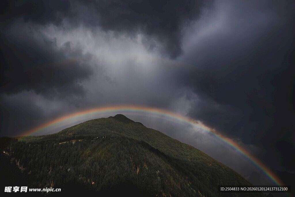 山间彩虹横跨乌云密布处