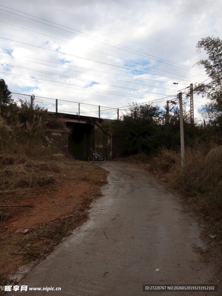 乡村泥泞小路与远处桥梁