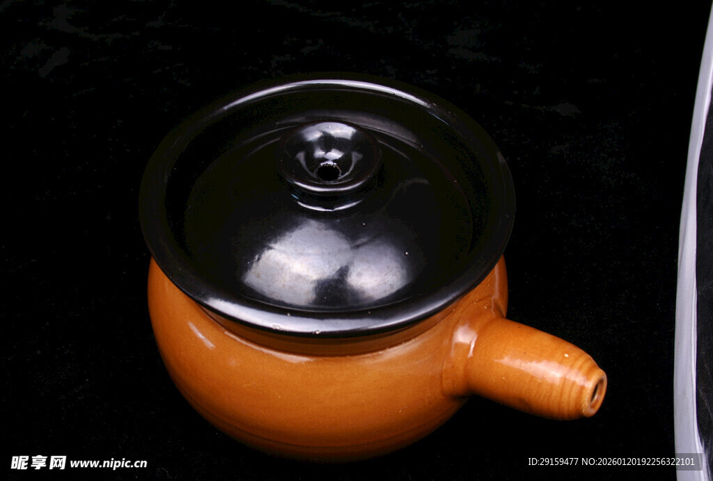 橙色陶制茶壶带黑色壶盖