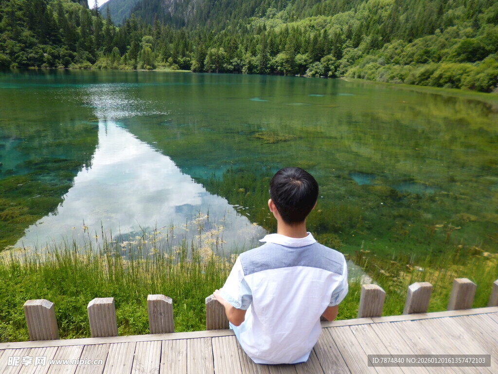 男孩静赏湖畔青山美景