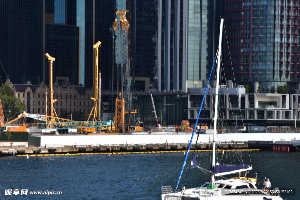 城市港口边的帆船与塔吊