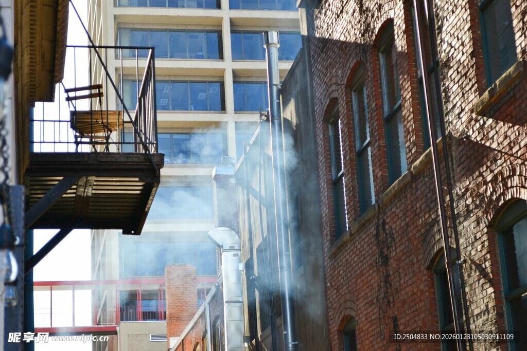 城市旧建筑旁升腾的烟雾