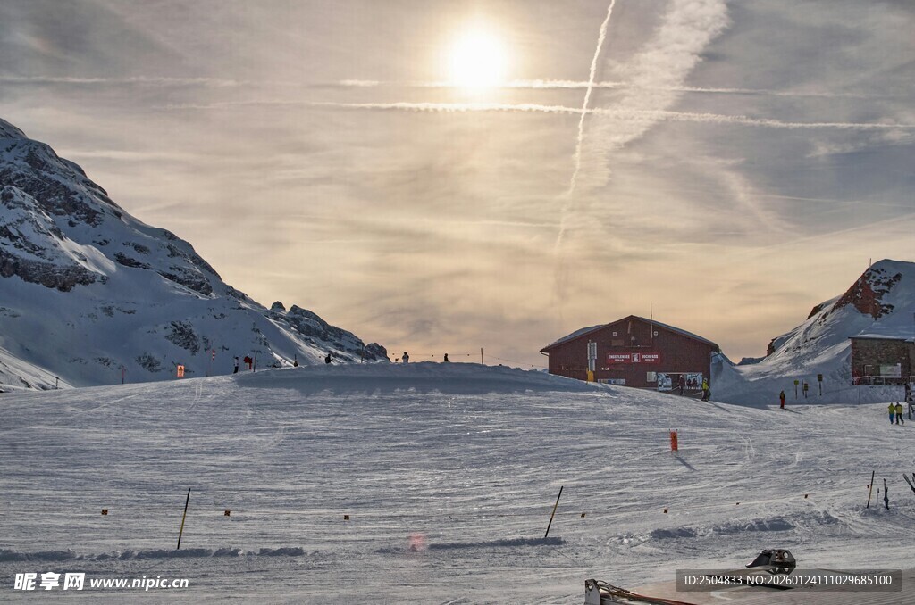 冬日雪山下的红顶小屋