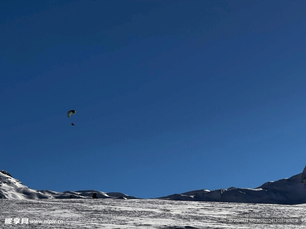 蓝天雪地间的滑翔伞