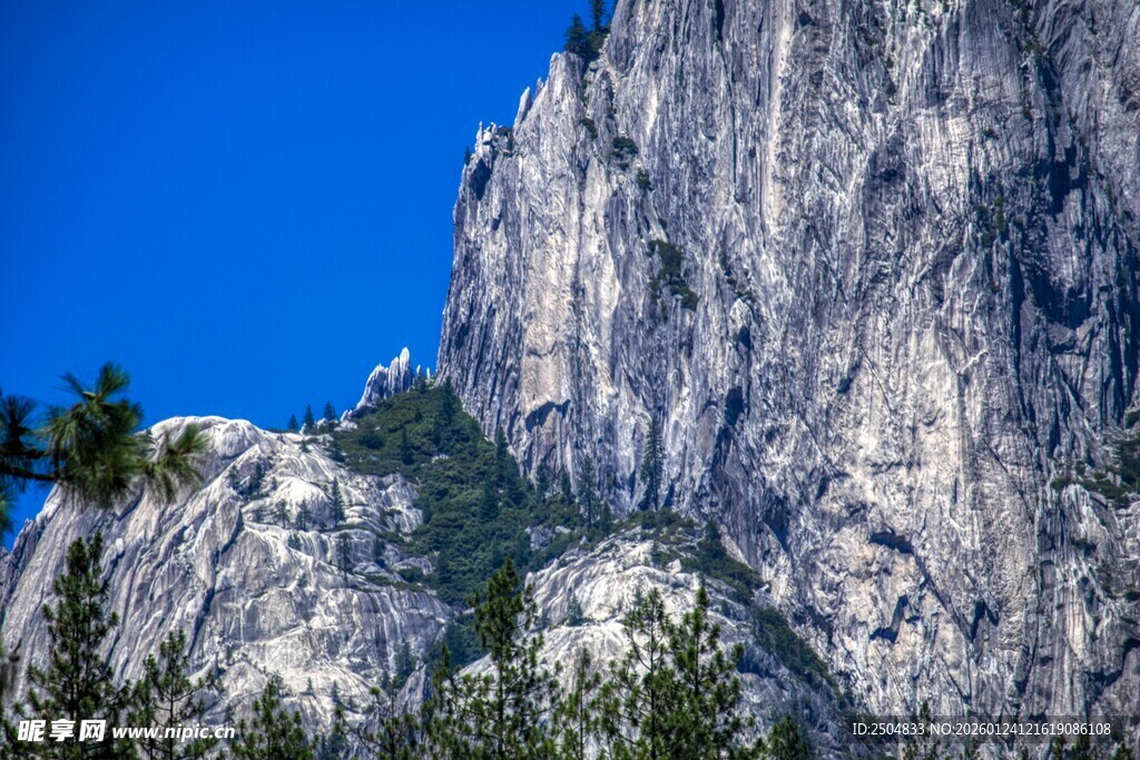 巍峨山峰与蓝天绿树相映