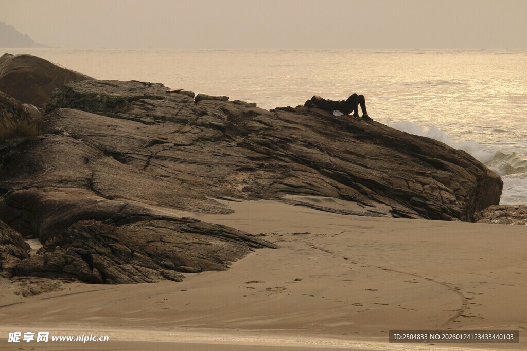 海边岩石上的孤独身影