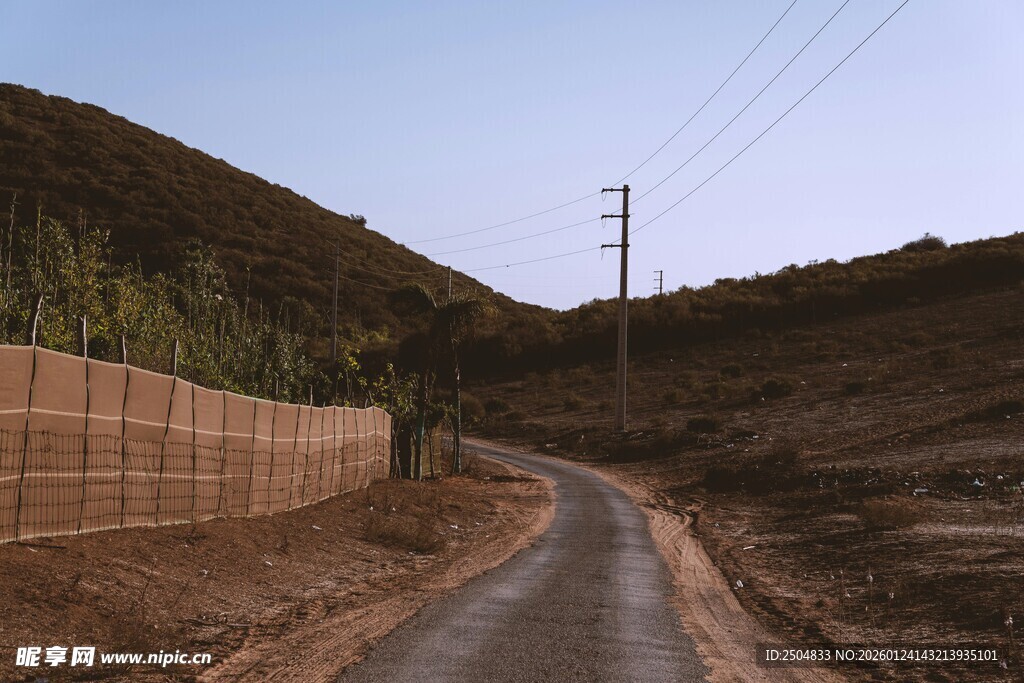 蜿蜒山路旁的土墙与电线杆