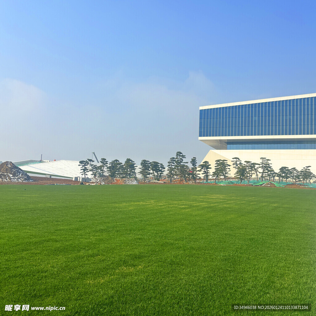 蓝白建筑旁的翠绿草坪