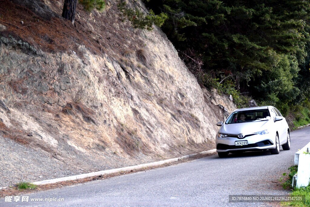 山间公路上行驶的白色汽车