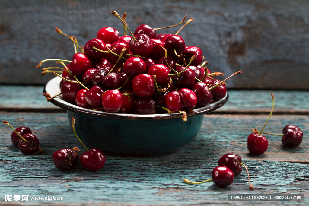木桌上碗中饱满的红樱桃