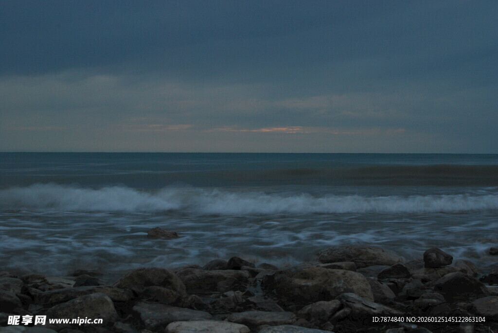 海边暮色中的礁石与海浪