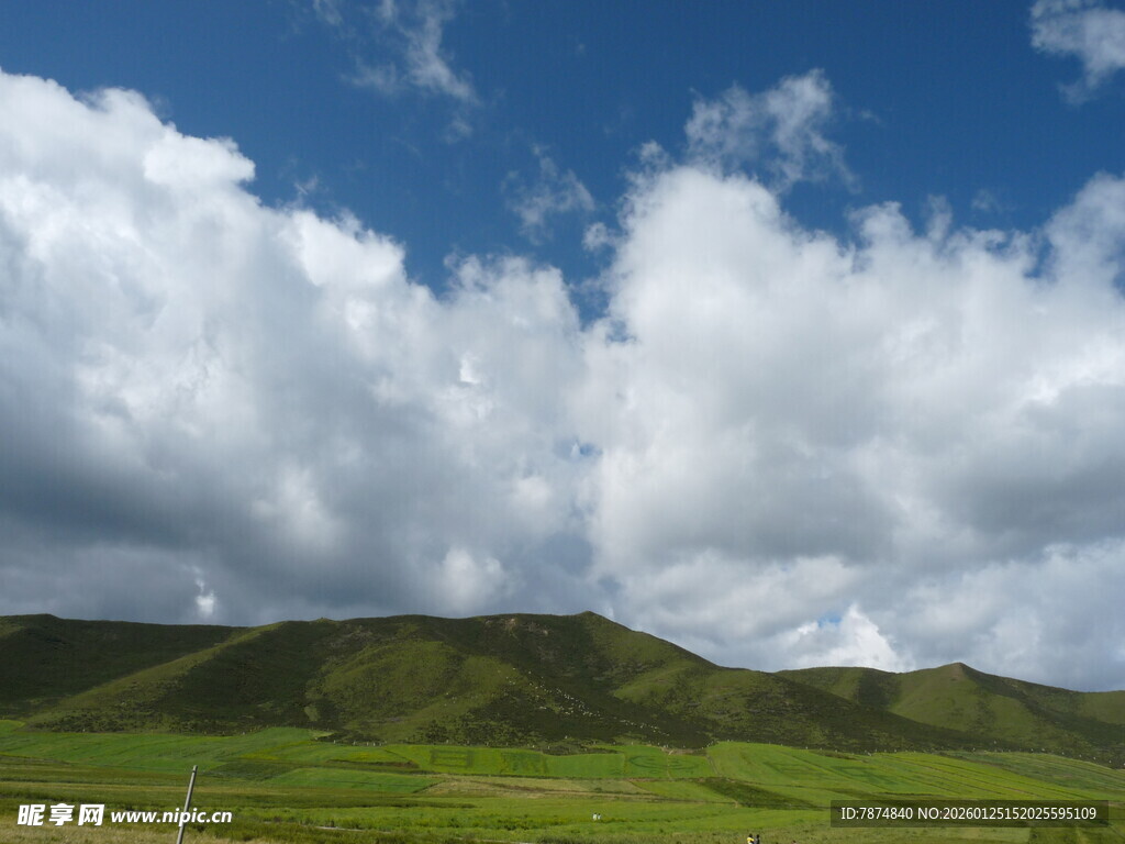 蓝天白云下的翠绿山丘