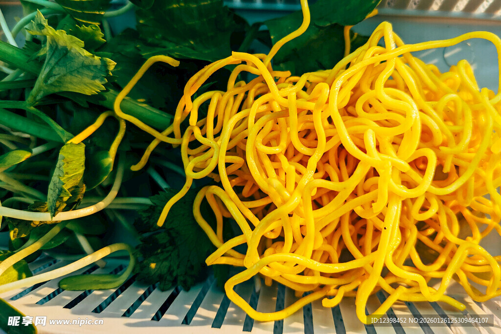 新鲜黄色面条与绿叶蔬菜
