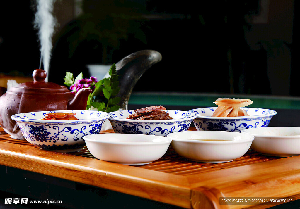 中式茶具摆放在古朴茶盘上