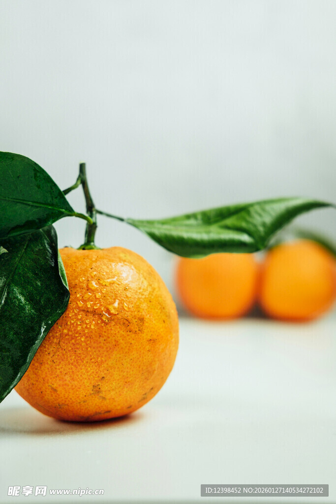 新鲜橘子带叶摆放在桌面