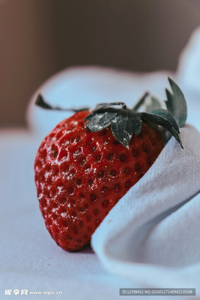 鲜红草莓置于白色布面