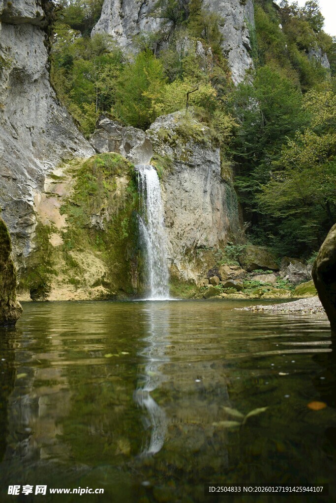山间瀑布下的静谧湖水