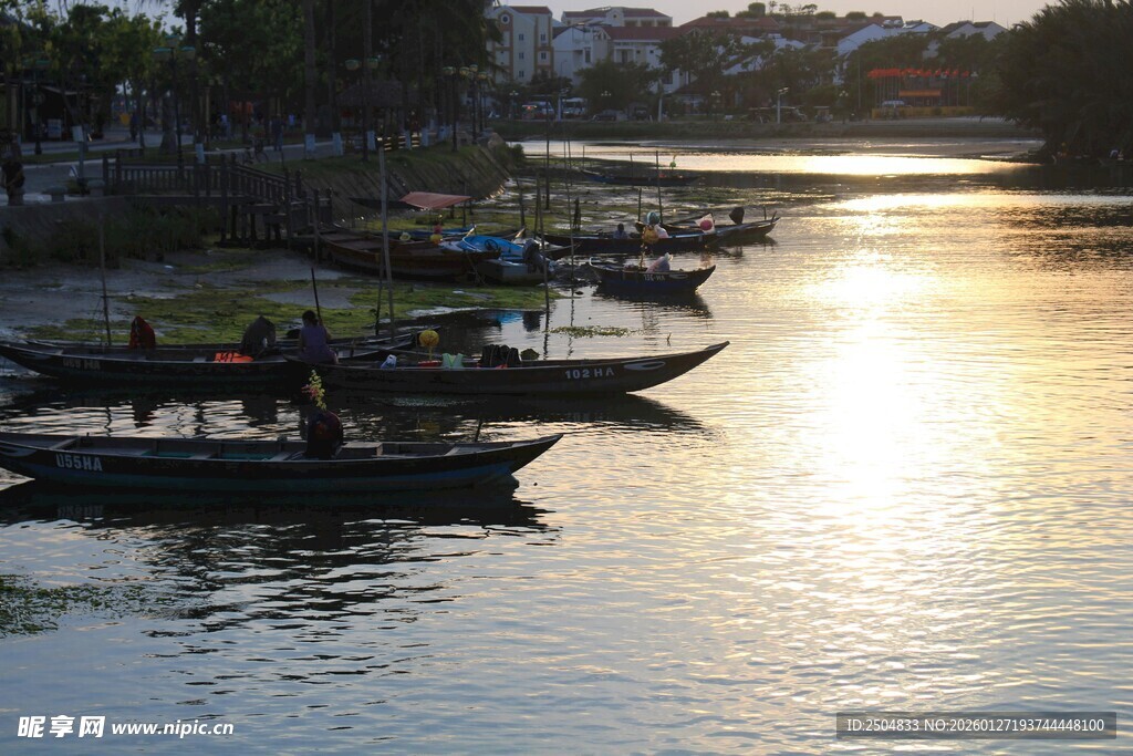 夕阳下的河畔停泊船只