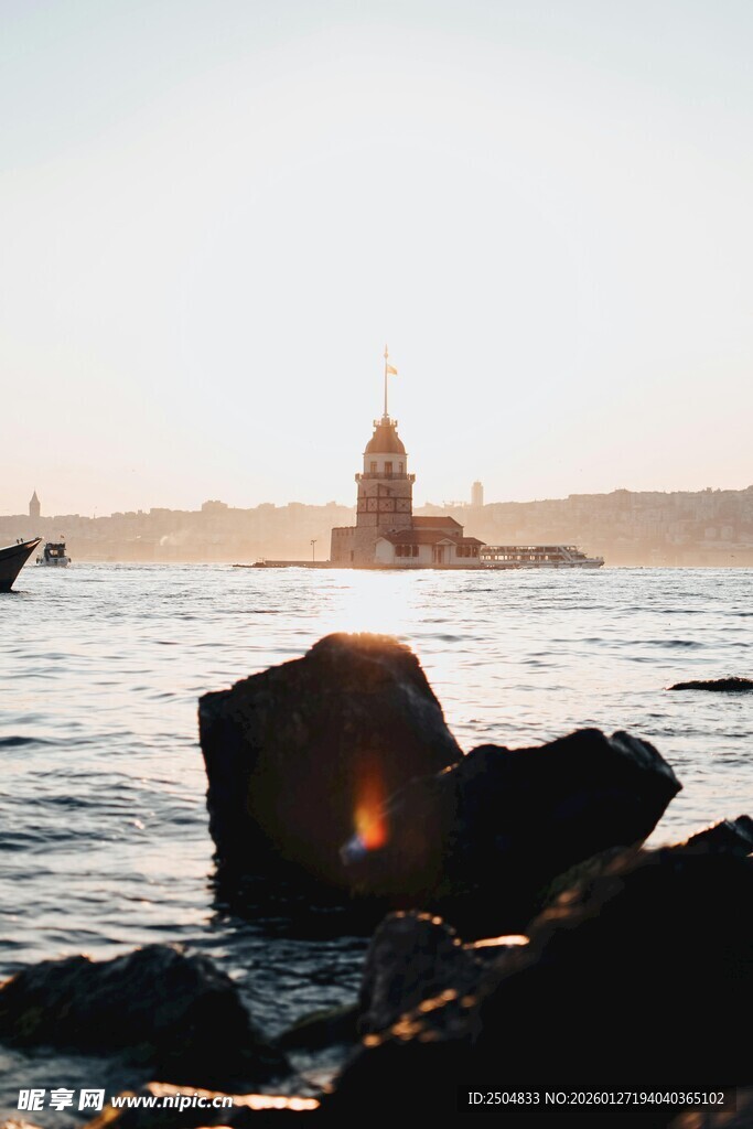 海边落日下的礁石与船只