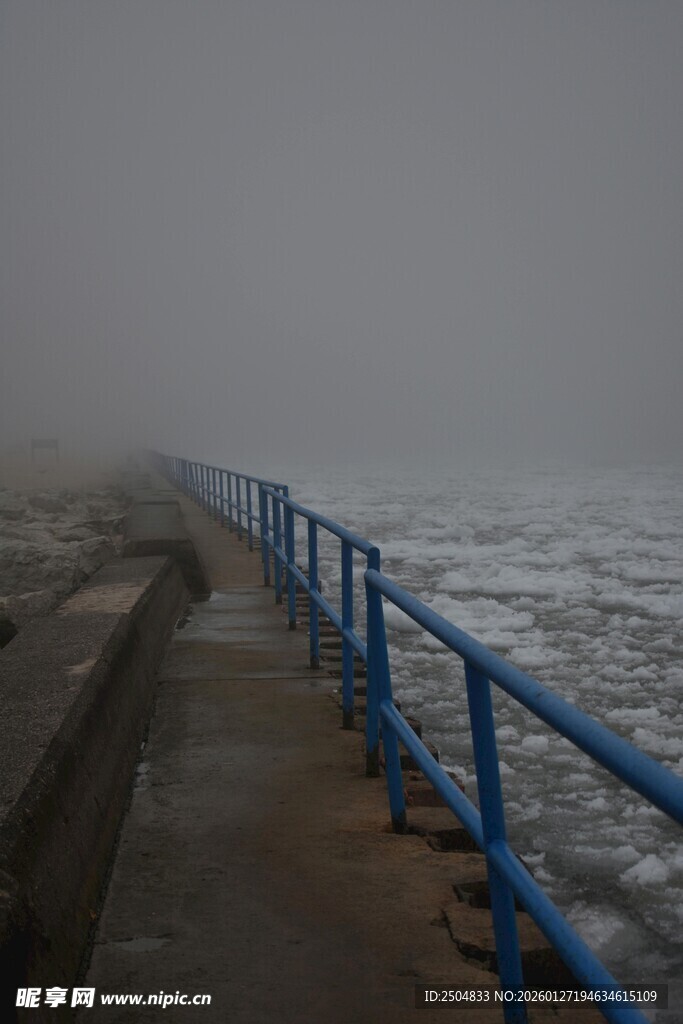 雾中海边蓝色护栏步道