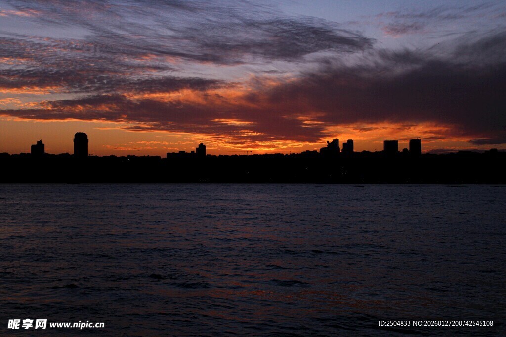 夕阳下的城市与水面剪影