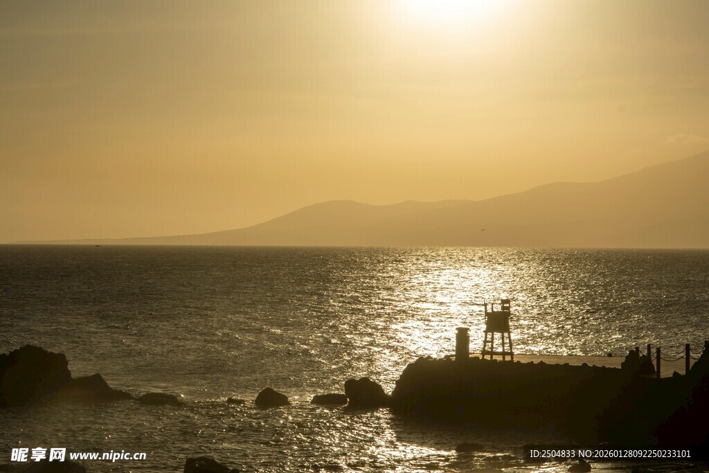 夕阳下海边的浪漫二人身影