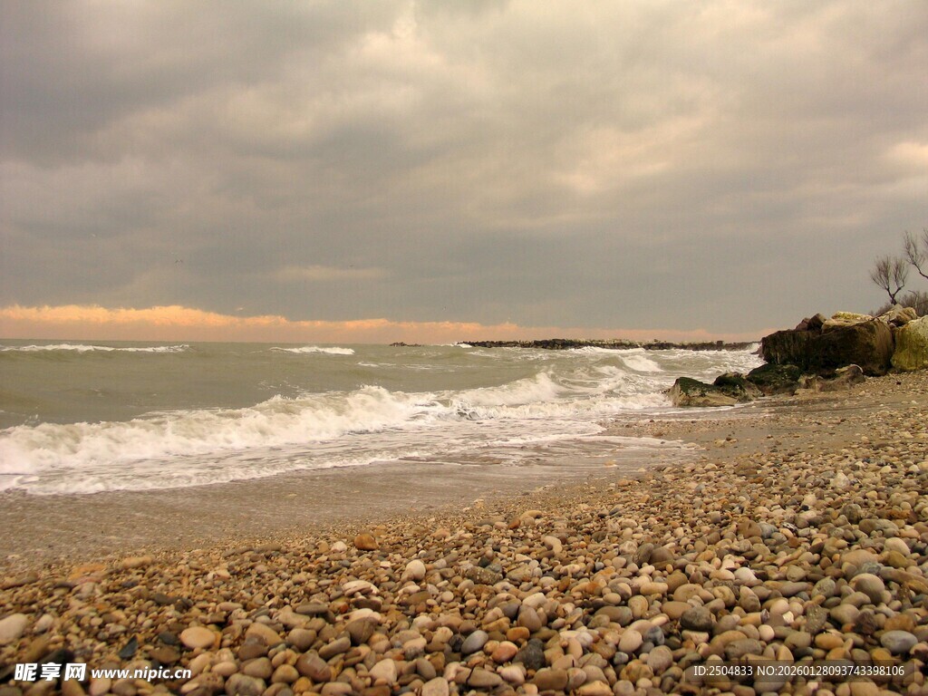 黄昏下的海浪拍打石滩