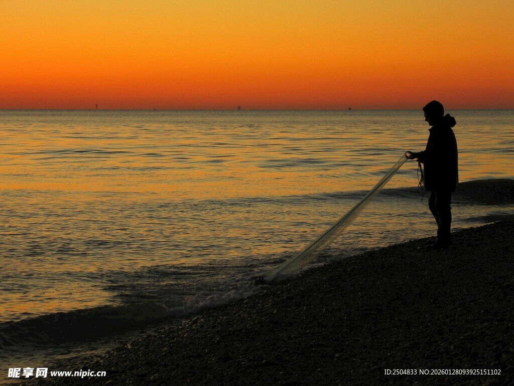 夕阳下海边垂钓者