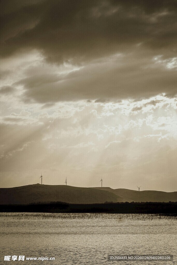 乌云下的湖面与远处风车